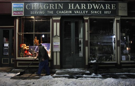 Rob Schwind shovels the sidewalk in front of the Chagrin Hardware in Chagrin Falls, Ohio.